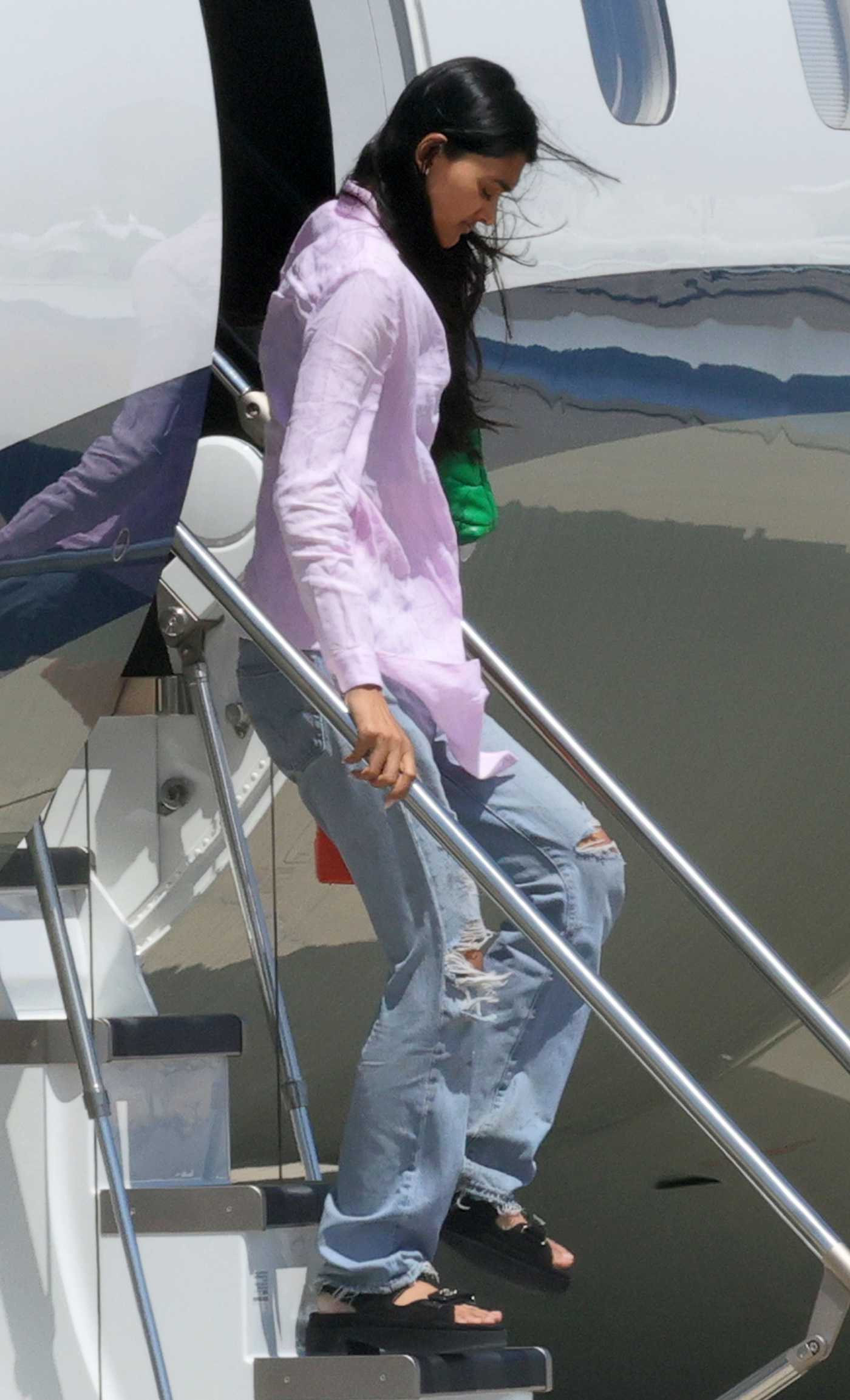 Neelam Gill in a Blue Ripped Jeans Arrives with Friends by a Private Jet in Sardinia 07/26/2023
