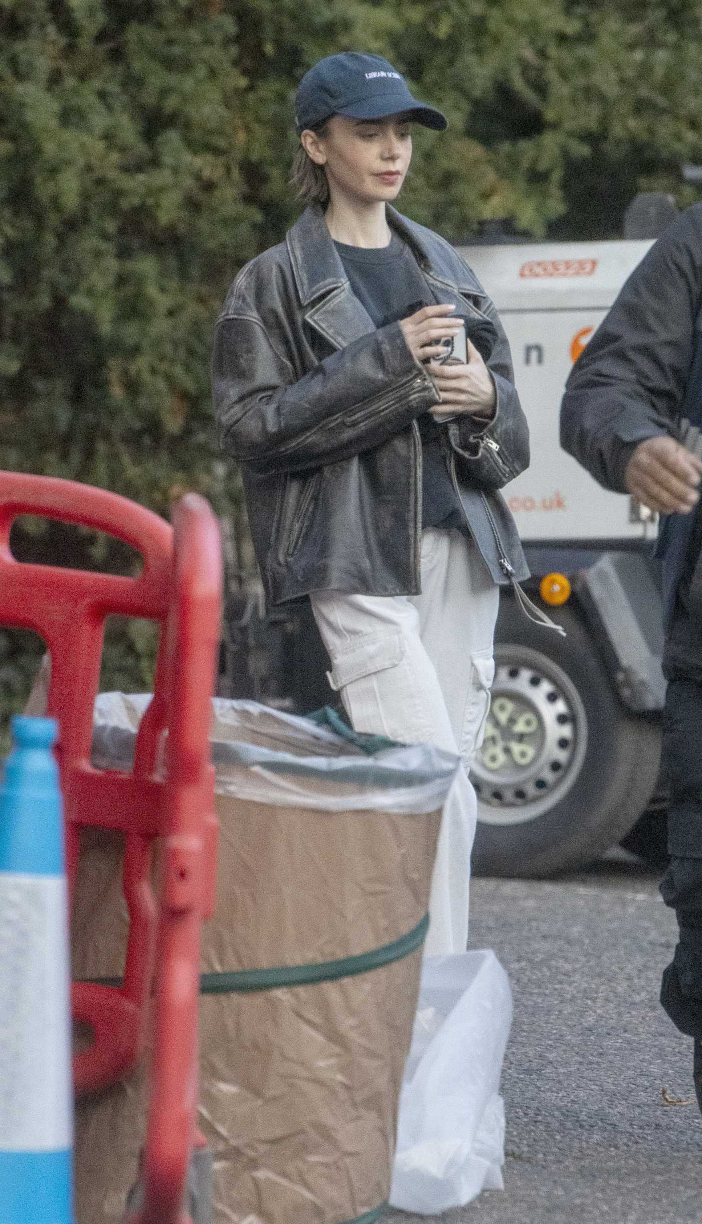 Lily Collins in a Black Leather Jacket on the Set of Close Personal Friends in London 09/21/2025